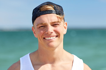Image showing close up of smiling young man on summer beach