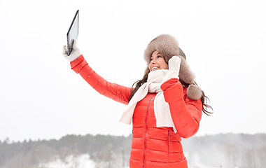 Image showing woman in winter fur hat with tablet pc outdoors