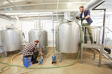 Image showing men working at craft beer brewery kettles