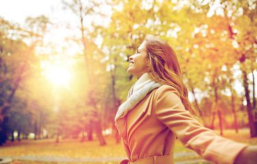 Image showing beautiful happy young woman walking in autumn park