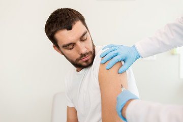 Image showing male patient and doctor hands with syringe