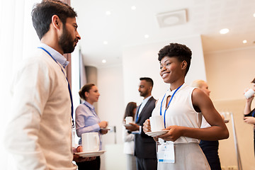 Image showing business people with conference badges and coffee