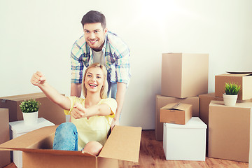 Image showing happy couple having fun with boxes at new home