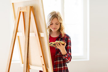 Image showing student girl with easel painting at art school