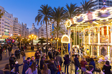 Image showing Christmas fair with carousel on Modernisme Plaza of the City Hall of Valencia, Spain.