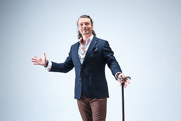 Image showing The mature barded man in a suit holding cane.