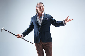 Image showing The mature barded man in a suit holding cane.