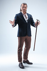 Image showing The mature barded man in a suit holding cane.