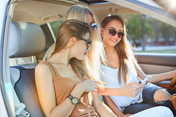 Image showing The pretty european girls 25-30 years old in the car make photo on mobile phone