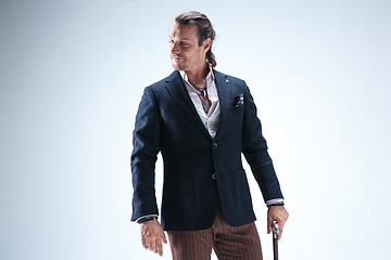 Image showing The mature barded man in a suit holding cane.