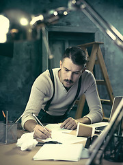 Image showing Architect working on drawing table in office