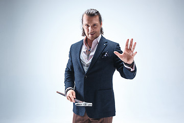 Image showing The mature barded man in a suit holding cane.