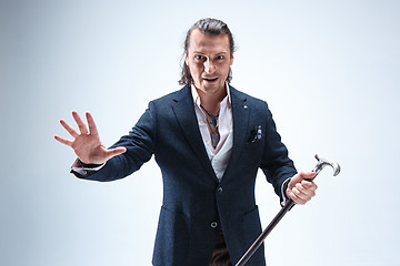 Image showing The mature barded man in a suit holding cane.