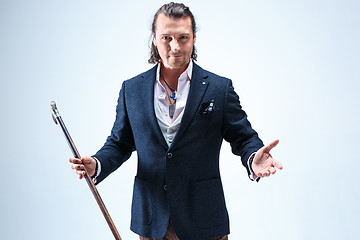 Image showing The mature barded man in a suit holding cane.