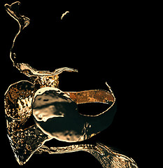 Image showing Melted gold or oil splashes isolated on black