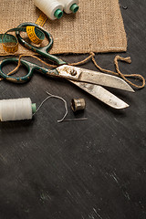 Image showing Retro sewing accessories on black wooden background