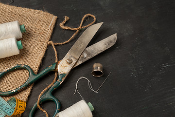 Image showing Retro sewing accessories on black wooden background