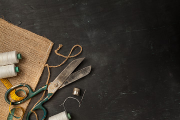 Image showing Retro sewing accessories on black wooden background
