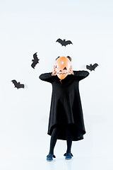 Image showing Little girl witch in black dress over magical accessories. Halloween, the studio evening.