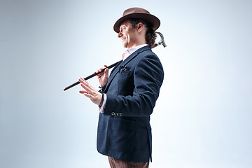 Image showing The mature man in a suit and hat holding cane.