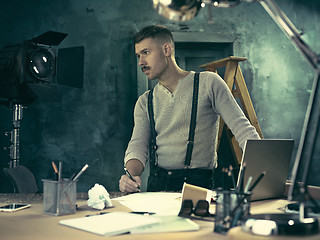 Image showing Architect working on drawing table in office