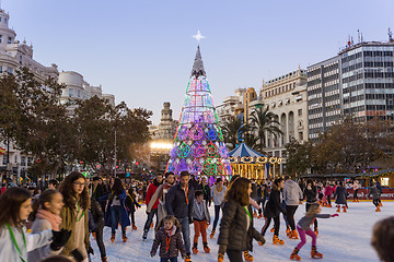 Image showing Christmas fair with people ice skating on Modernisme Plaza of the City Hall of Valencia, Spain.