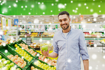 Image showing happy man buying green apples at grocery store