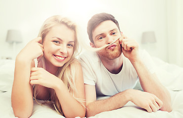 Image showing happy couple lying in bed at home