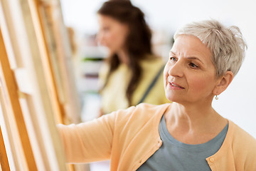 Image showing woman artist with easel drawing at art school