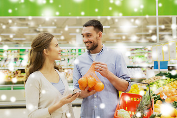 Image showing happy couple buying oranges at grocery store