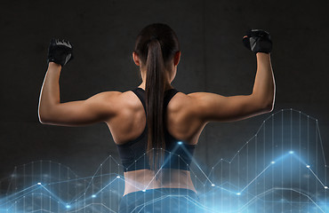 Image showing young woman flexing muscles in gym