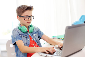 Image showing student boy in glasses typing on laptop at home