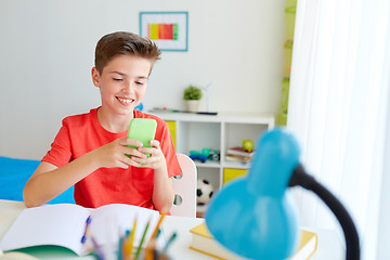 Image showing student boy with smartphone distracting from study