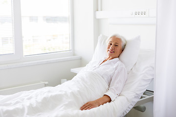 Image showing smiling senior woman lying on bed at hospital ward