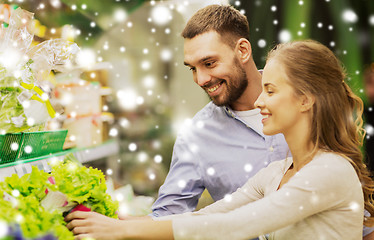 Image showing happy couple buying lettuce at grocery store