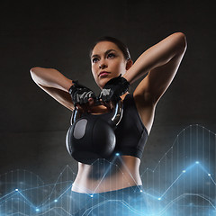 Image showing young woman flexing muscles with kettlebell in gym