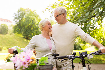 Image showing happy senior couple with bicycles at summer park