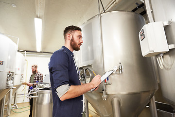 Image showing men with clipboard at craft brewery or beer plant