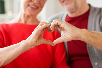 Image showing close up of senior couple showing hand heart sign