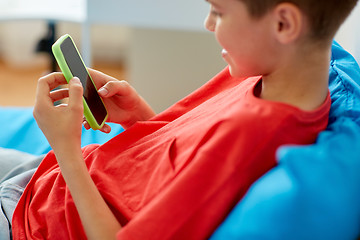 Image showing happy smiling boy with smartphone at home