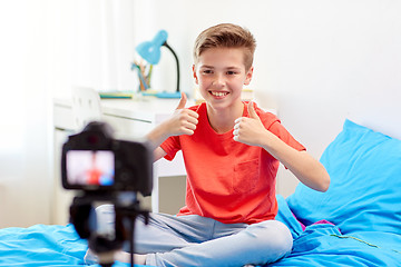 Image showing happy boy with camera recording video at home