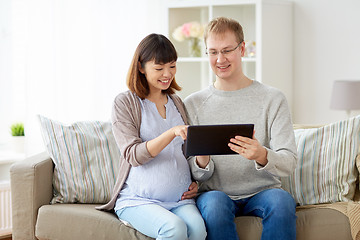 Image showing husband and pregnant wife with tablet pc at home