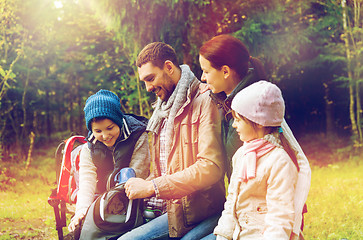 Image showing happy family with backpacks and thermos at camp