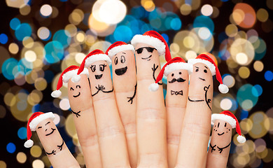 Image showing close up of fingers in santa hats at christmas