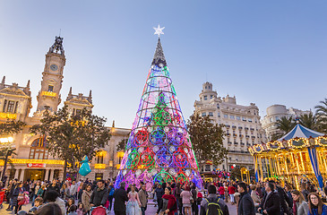 Image showing Christmas fair with colorful christmas tree and carousel on Modernisme Plaza of the City Hall of Valencia, Spain.