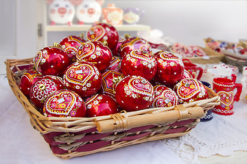 Image showing Red Christmas balls in wicker basket, hand painted with traditio