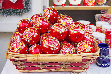 Image showing Red Christmas balls in wicker basket, hand painted with traditio