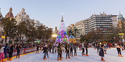 Image showing Christmas fair with people ice skating on Modernisme Plaza of the City Hall of Valencia, Spain.