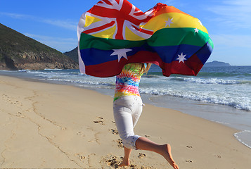 Image showing Marriage Equality  Joyous woman running along the beach with a r