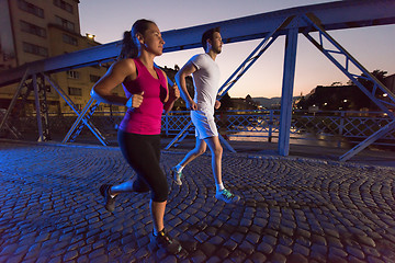 Image showing couple jogging across the bridge in the city